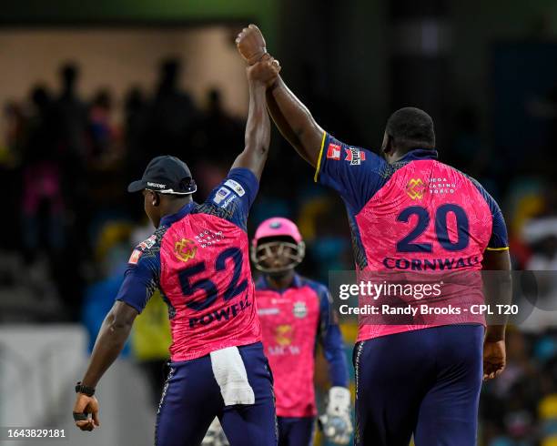 Rovman Powell holds up Rahkeem Cornwall of Barbados Royals hand for taking two Saint Kitts and Nevis Patriots wickets during the Men's 2023 Republic...