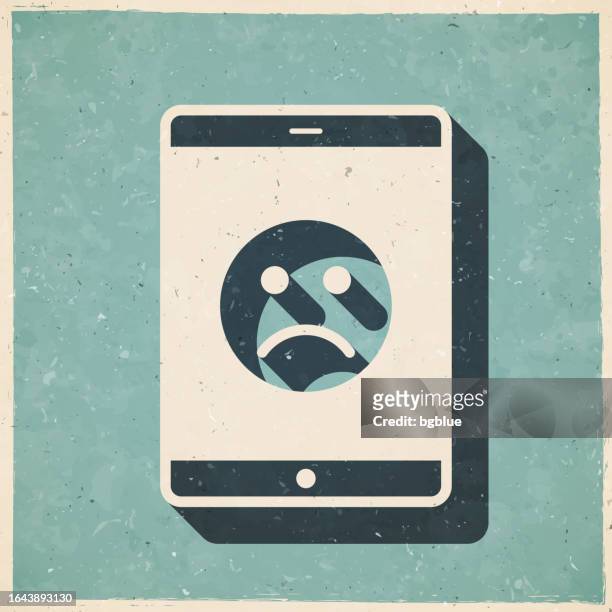tablet pc with sad emoji. icon in retro vintage style - old textured paper - disappointing phone stock illustrations