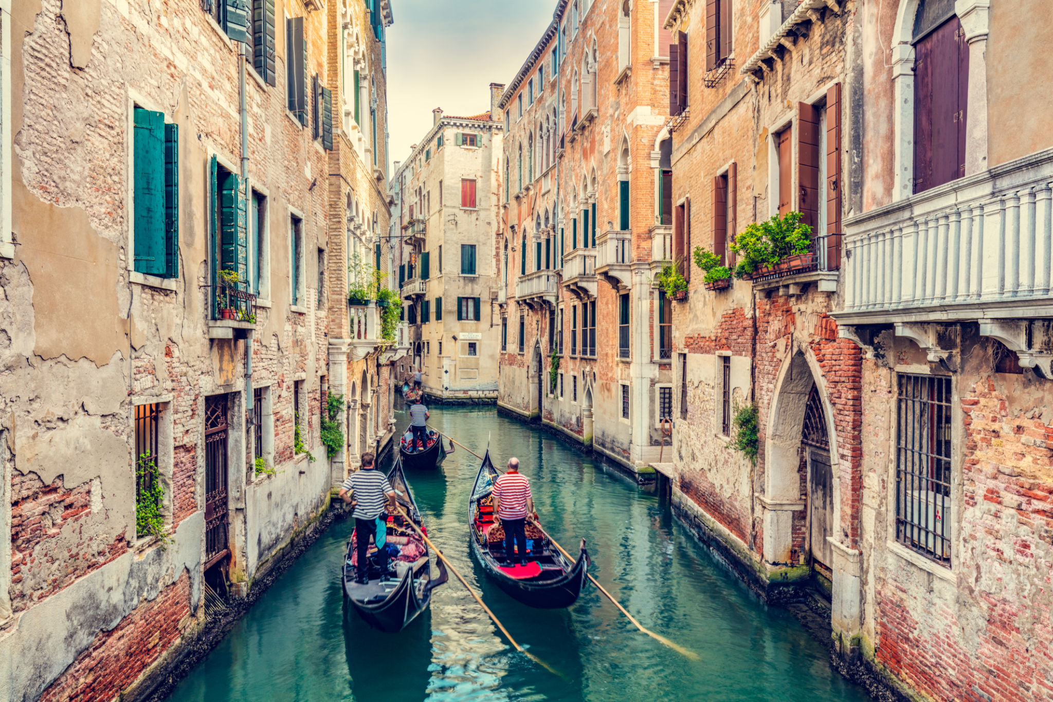 Gondolier rowing gondola on canal in Venice, Italy. Gondolier rowing gondola on canal in Venice, Italy.