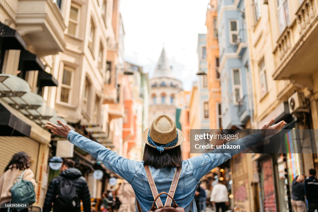 Mulher nova enjoing a vista da torre de gálata em Istambul