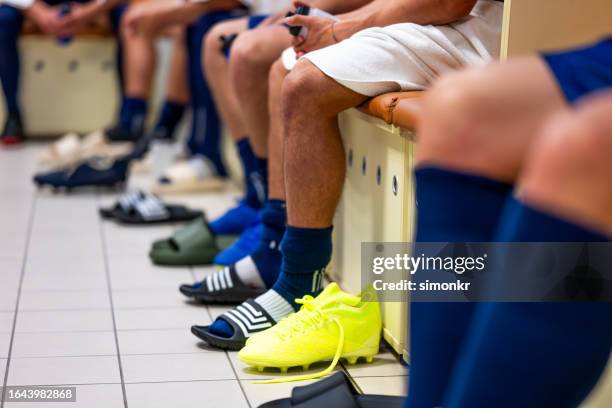 football players sitting in dressing room - locker room stock pictures, royalty-free photos & images