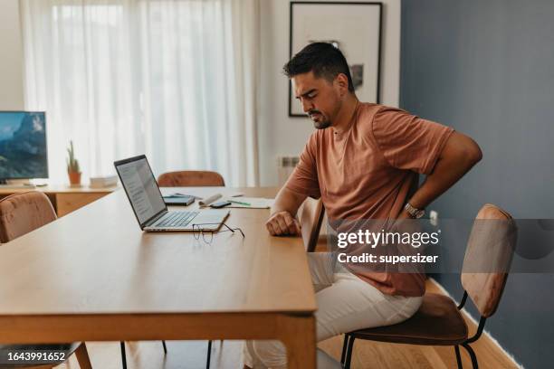 one man experiencing back pain - backache stock pictures, royalty-free photos & images