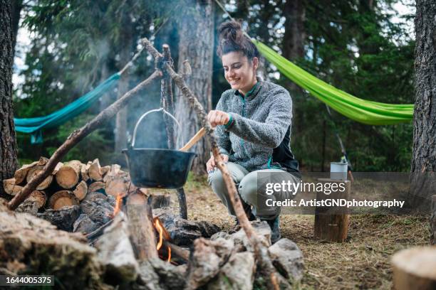 frau kocht essen auf dem lagerfeuer. - suppentopf stock-fotos und bilder