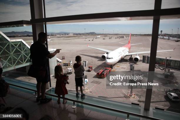 Man and two children look at the Shenzhen Airlines plane that has made the first direct Barcelona-Shenzhen flight, at T1 of El Prat airport, Aug. 28...