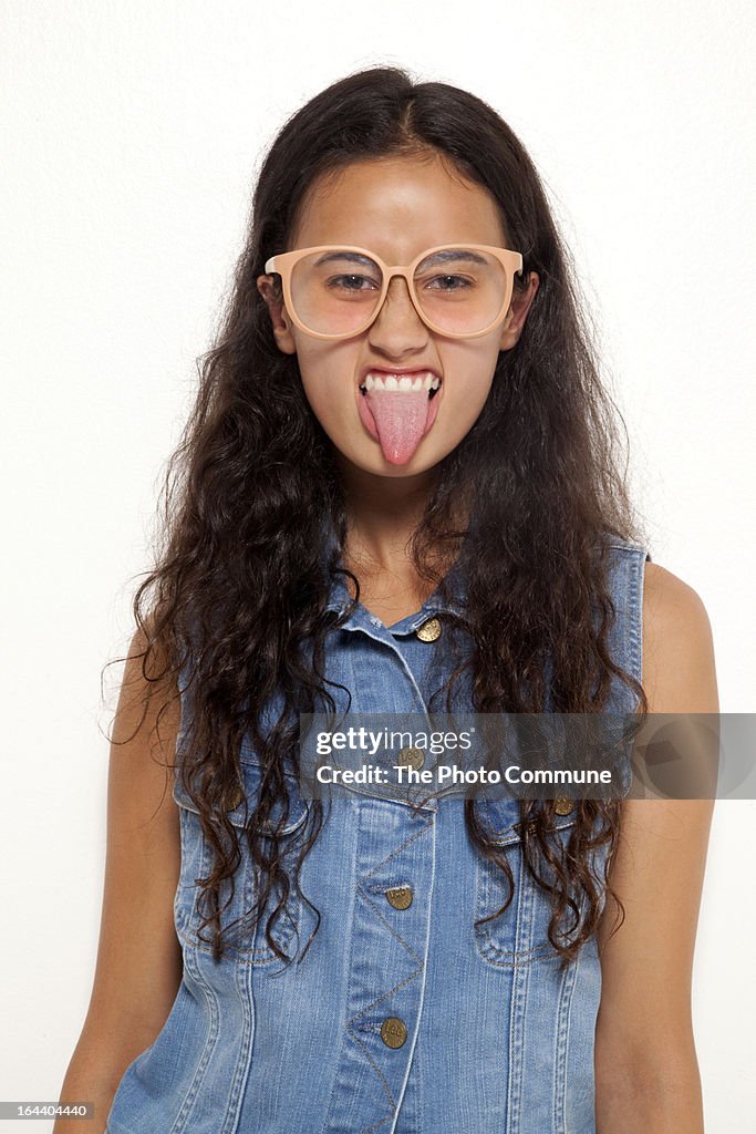 Teenage girl studio poking out tongue for camera
