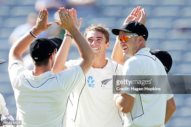 Tim Southee of New Zealand is congratulated by teammates Hamish Rutherford and Peter Fulton after dismissing Ian Bell of England during day three of...