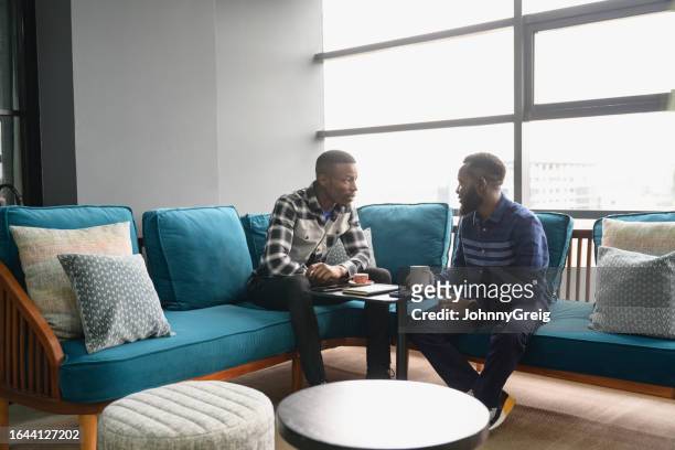 male professionals sharing ideas in nairobi coworking office - nairobi county stock pictures, royalty-free photos & images