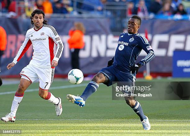 Mechack Jerome of Sporting KC beats Juan Toja of New England Revolution to the ball in the second half at Gillette Stadium on March 23, 2013 in...