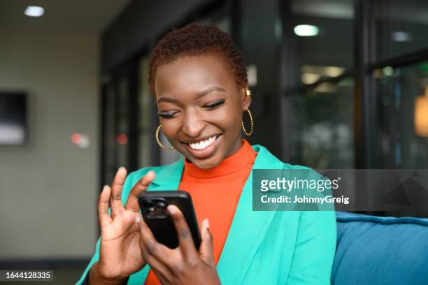 fröhlicher junger geschäftsmann mit smartphone - african lady sitting and looking at her smartphone stock-fotos und bilder