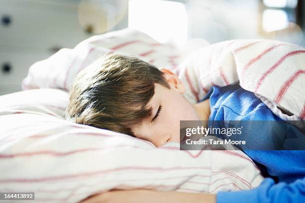 young boy fast asleep in bed - kind schlafen stock-fotos und bilder