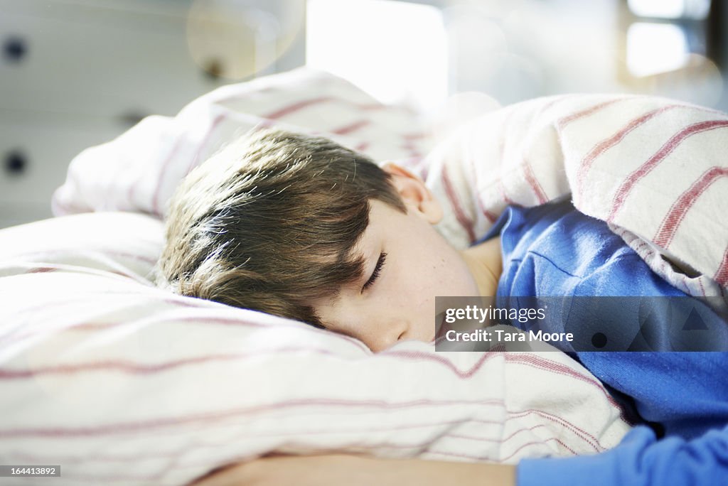 Young boy fast asleep in bed