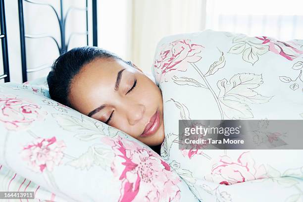 portrait of young woman asleep in bed - bedding stock pictures, royalty-free photos & images
