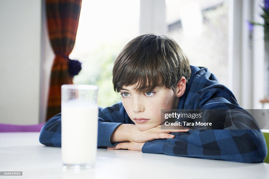 Boy looking bored with glass of milk
