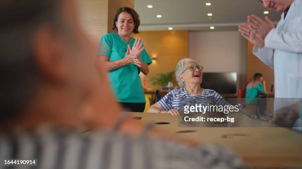 due donne adulte anziane che giocano come fisioterapia in casa di cura - promises rehab center foto e immagini stock