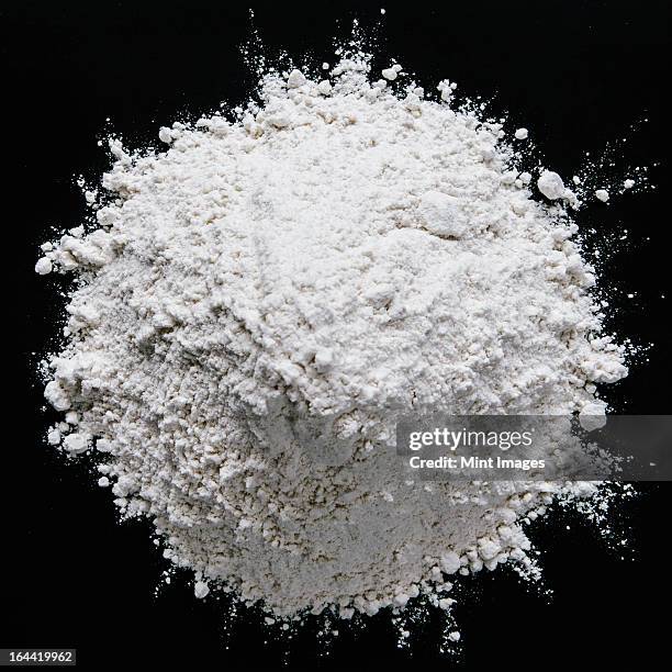 pile of organic unbleached white flour, black backdrop - flour foto e immagini stock