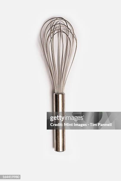 a metal balloon cooking whisk with metal handle. - wire whisk stock pictures, royalty-free photos & images