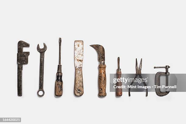 used tools arranged in a row. well used, worn handles, shaped wooden smooth texture. metal rusty and marked implements. - werkzeug stock-fotos und bilder