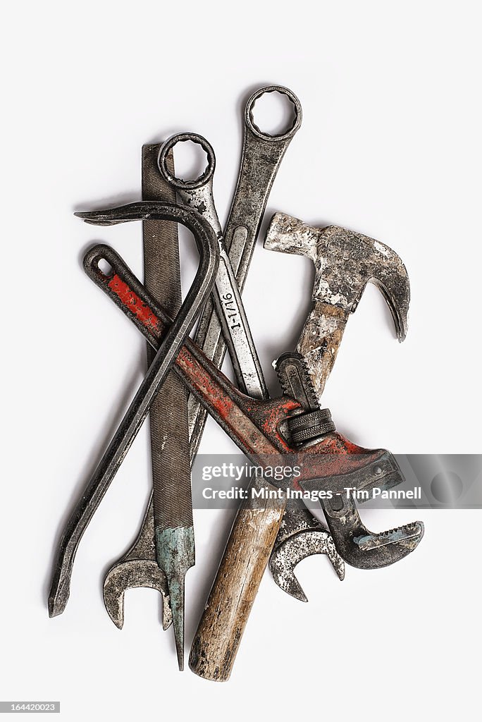 Used Tools. A group of spanners, adjustable wrench and hammer. Worn marked metal handheld tools.