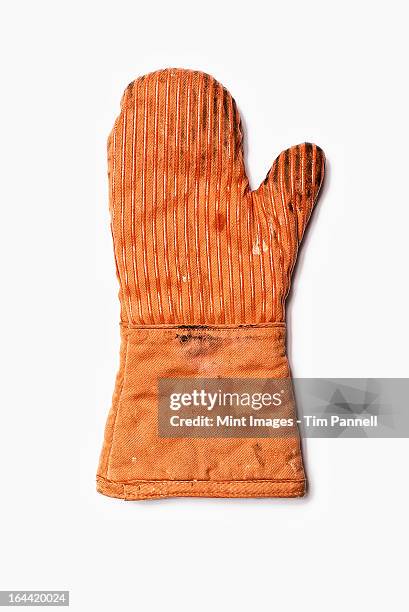 used oven mitt. an orange fabric heat resistant mitt. - oven mitt stock pictures, royalty-free photos & images