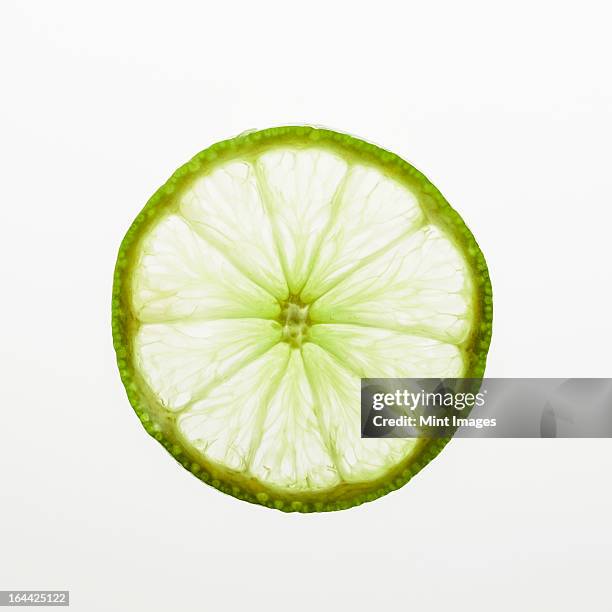 organic lime slice on white background - limes stock pictures, royalty-free photos & images