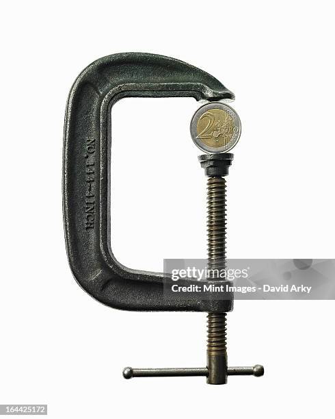 an european currency coin in a metal clamp. euro. - schraubstock stock-fotos und bilder