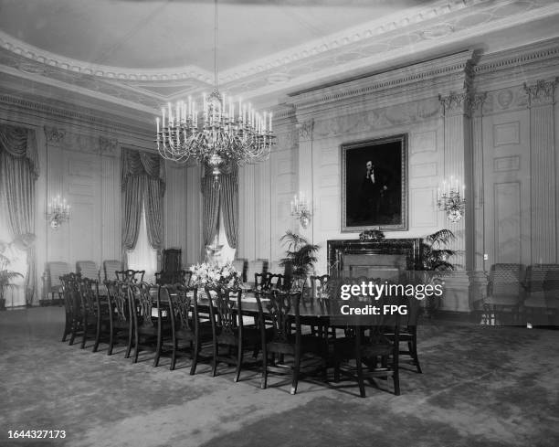 The State Dining Room, with a portrait of Abraham Lincoln hanging on the wall, in the White House, Washington, DC, 1948. The 1869 portrait was...