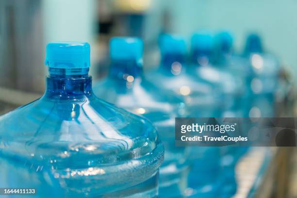 plastic bottle or gallon of purified drinking water inside drinking water or beverage factory which has automated conveyor production line. water manufacture - purified water stockfoto's en -beelden
