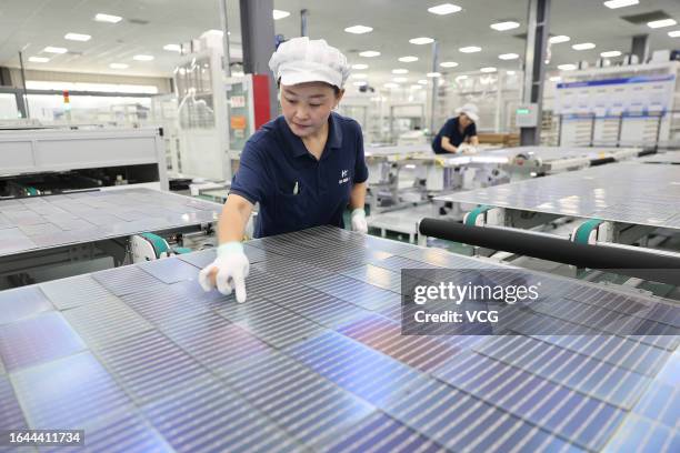 An employee works on the production line of solar panels at a photovoltaic enterprise on August 28, 2023 in Lianyungang, Jiangsu Province of China.