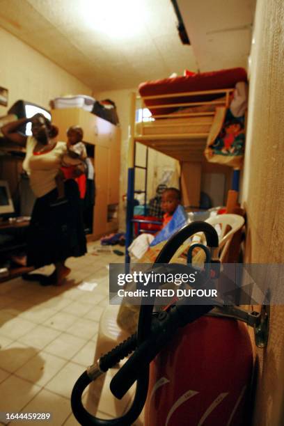 Woman and her children stand in their run-down apartment in Paris 24 August 2006. Several families, mostly from the Ivory Coast, live in cramped...