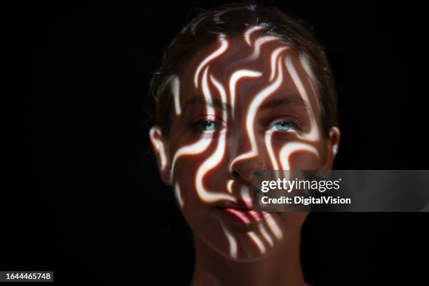 light on young woman's face - high contrast stock pictures, royalty-free photos & images