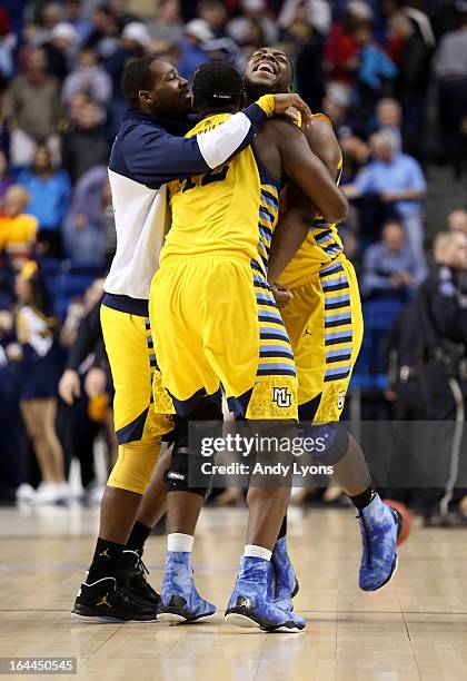 Davante Gardner and Chris Otule of the Marquette Golden Eagles celebrate with teammates after defeating the Butler Bulldogs during the third round of...