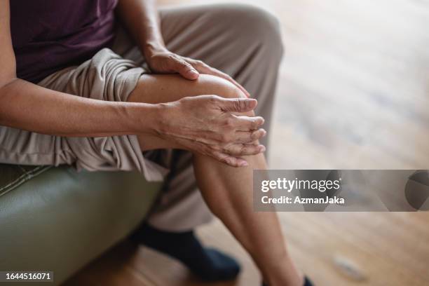 mujer mayor que tiene dolor en las articulaciones y la rodilla - artritis fotografías e imágenes de stock