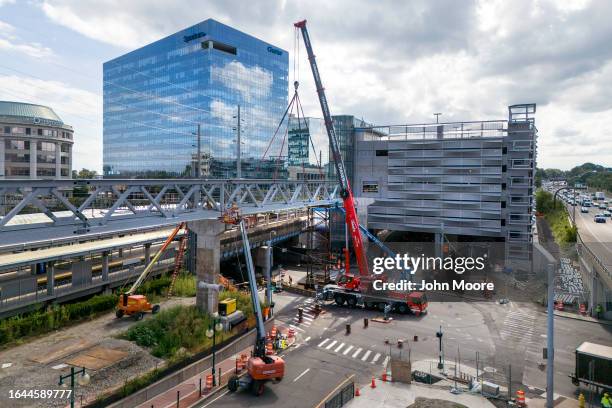 Workers connect a new pedestrian bridge at the Stamford Transportation Center on August 26, 2023 in Stamford, Connecticut.The bridge connects a newly...