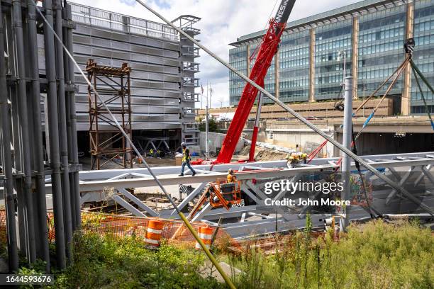 Workers prepare to lift a new pedestrian bridge into place at the Stamford Transportation Center on August 26, 2023 in Stamford, Connecticut. The...