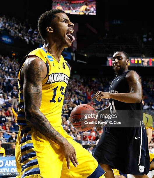 Vander Blue of the Marquette Golden Eagles reacts after stealing the ball and a dunk against Roosevelt Jones of the Butler Bulldogs in the second...