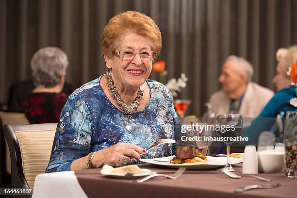 senior citizen woman enjoying her dining experience - beefsteak 2013 stock pictures, royalty-free photos & images