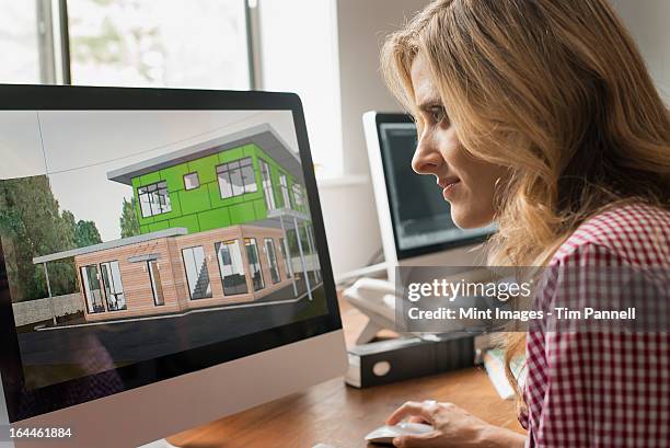 architects discussing a green construction project, designing and building efficient environmentally friendly buildings. green architectural practice. - cad screen stock pictures, royalty-free photos & images
