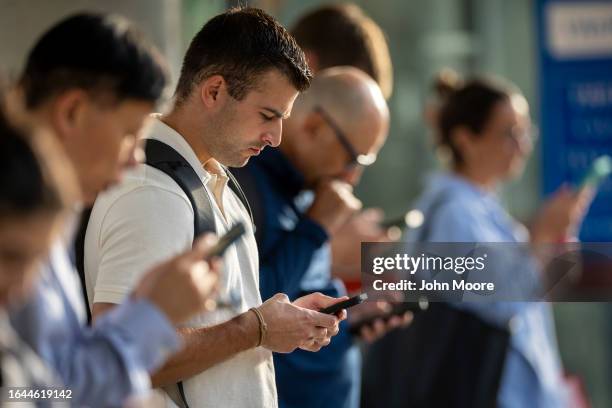 People check their phones as a Metro-North train approaches the Stamford Transportation Center on August 28, 2023 in Stamford, Connecticut. Major...