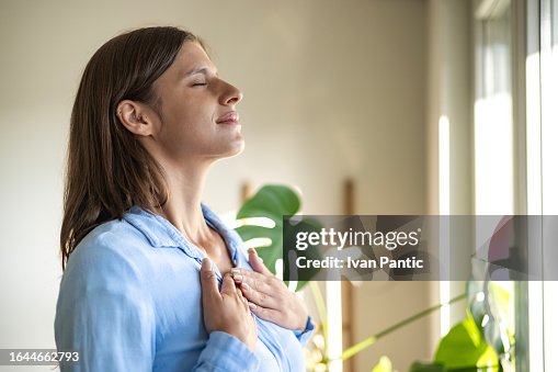 Happy woman open window drapes close eyes in delight Happy woman open window drapes close eyes in delight