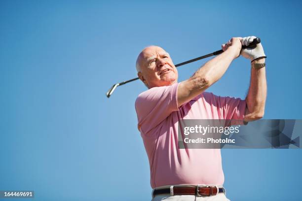 senior man swinging golf club - senior golf swing stock pictures, royalty-free photos & images