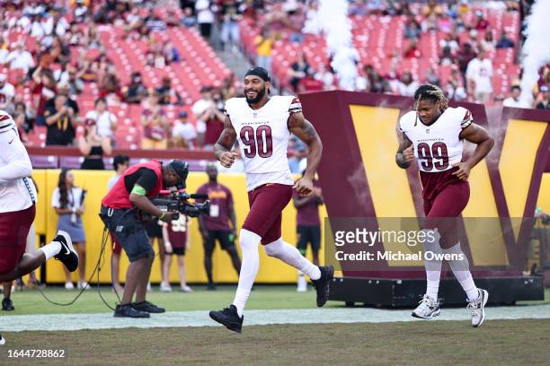 Montez Sweat of the Washington Commanders and Chase Young of the Washington Commanders run as they take the field prior to an NFL preseason game...