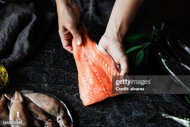 primo piano di uno chef che prepara filetto di salmone fresco in cucina - salmone foto e immagini stock