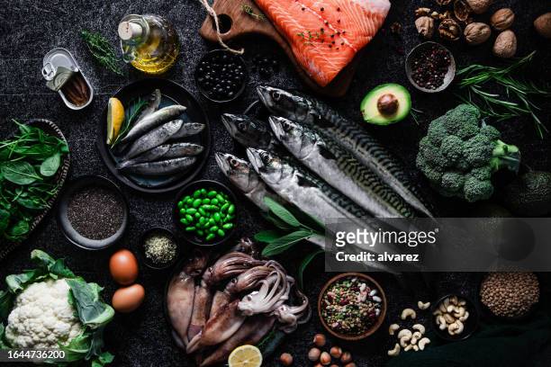 table top view of a delightful seafood feast on the kitchen table - raw fish stockfoto's en -beelden