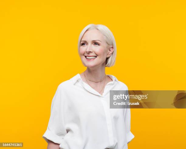 portrait of beautiful mature woman - yellow shirt stock pictures, royalty-free photos & images