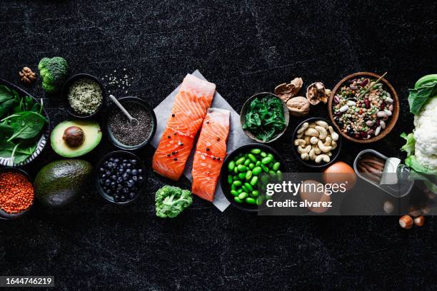top view of omega 3 food items on black table - eiwit organische verbinding stockfoto's en -beelden