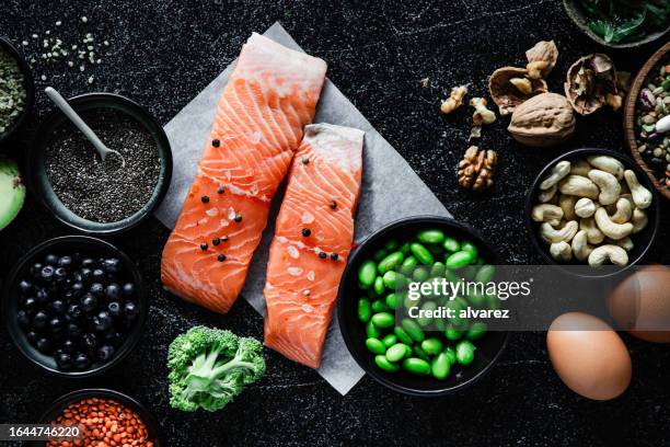 table top view of omega 3 rich food items on black background - cashew pieces stock pictures, royalty-free photos & images