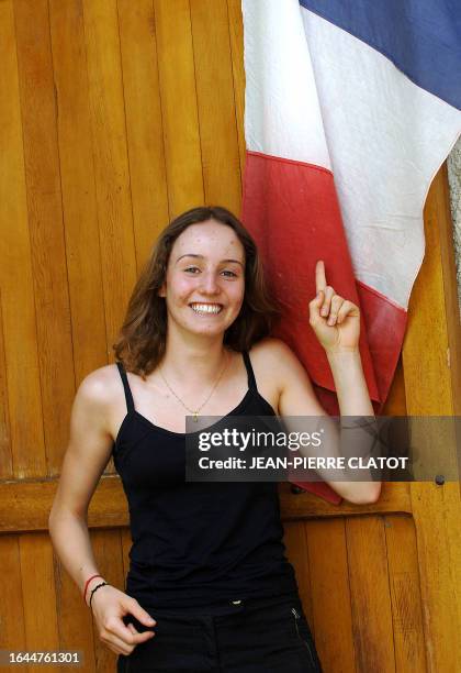 Marianne Tenant pose devant le drapeau national français en soutien à l'équipe de France de football le 04 juillet 2006, à son domicile à Saint Jean...