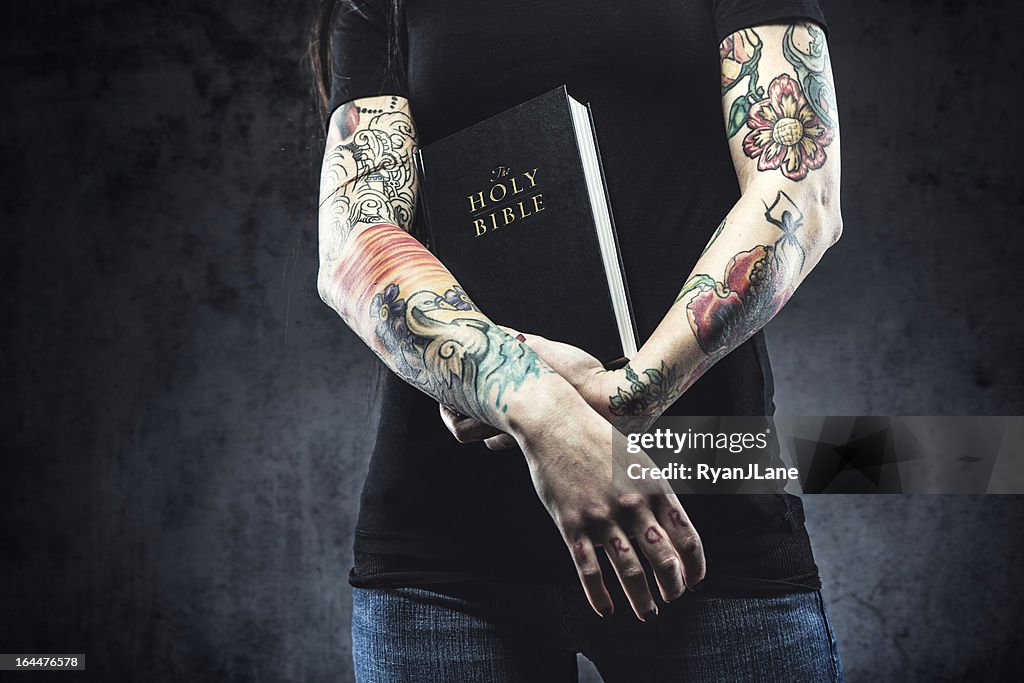 Bible in Arms of Tattooed Woman