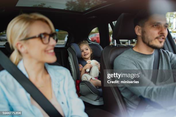 a happy cute child going on vacation with her family - auto interieur stockfoto's en -beelden