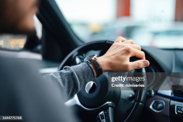 ein nicht wiederzuerkennender geschäftsmann, der sein auto fährt - steering wheel stock-fotos und bilder